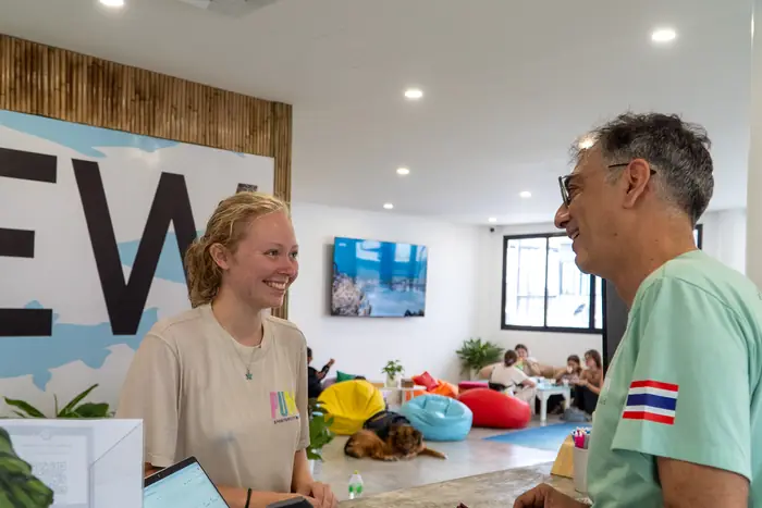 A guest checking in at reception with a smiling staff member