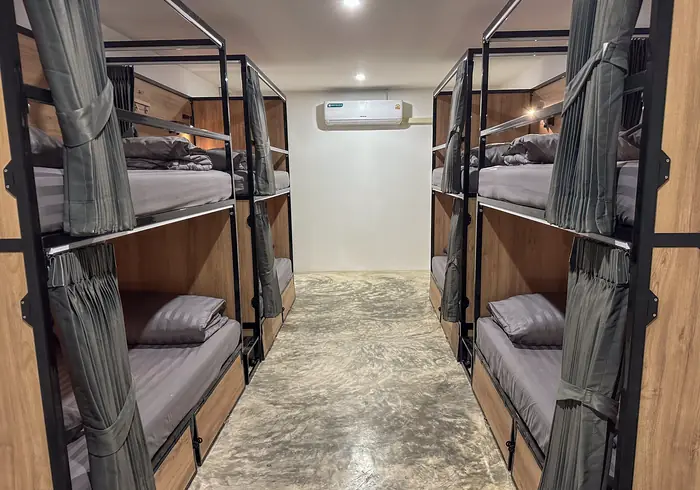 Aisle in daylight with privacy curtains drawn across the bunks