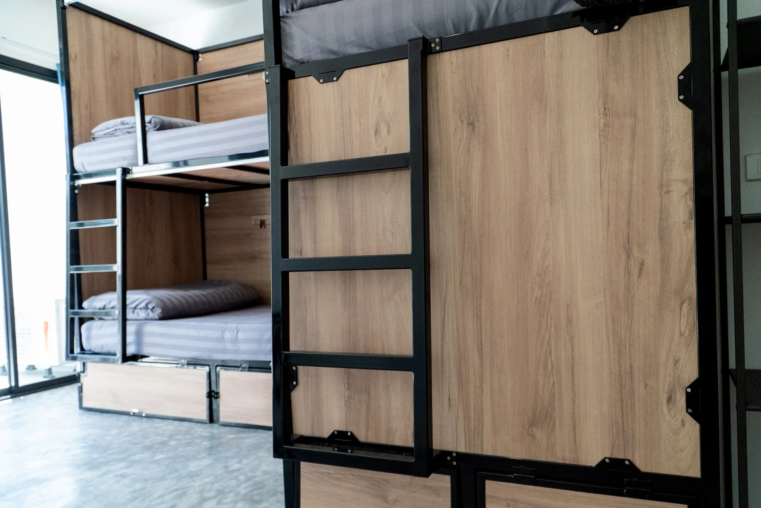 Ladder and storage drawers beside the bunks, daylight from the window
