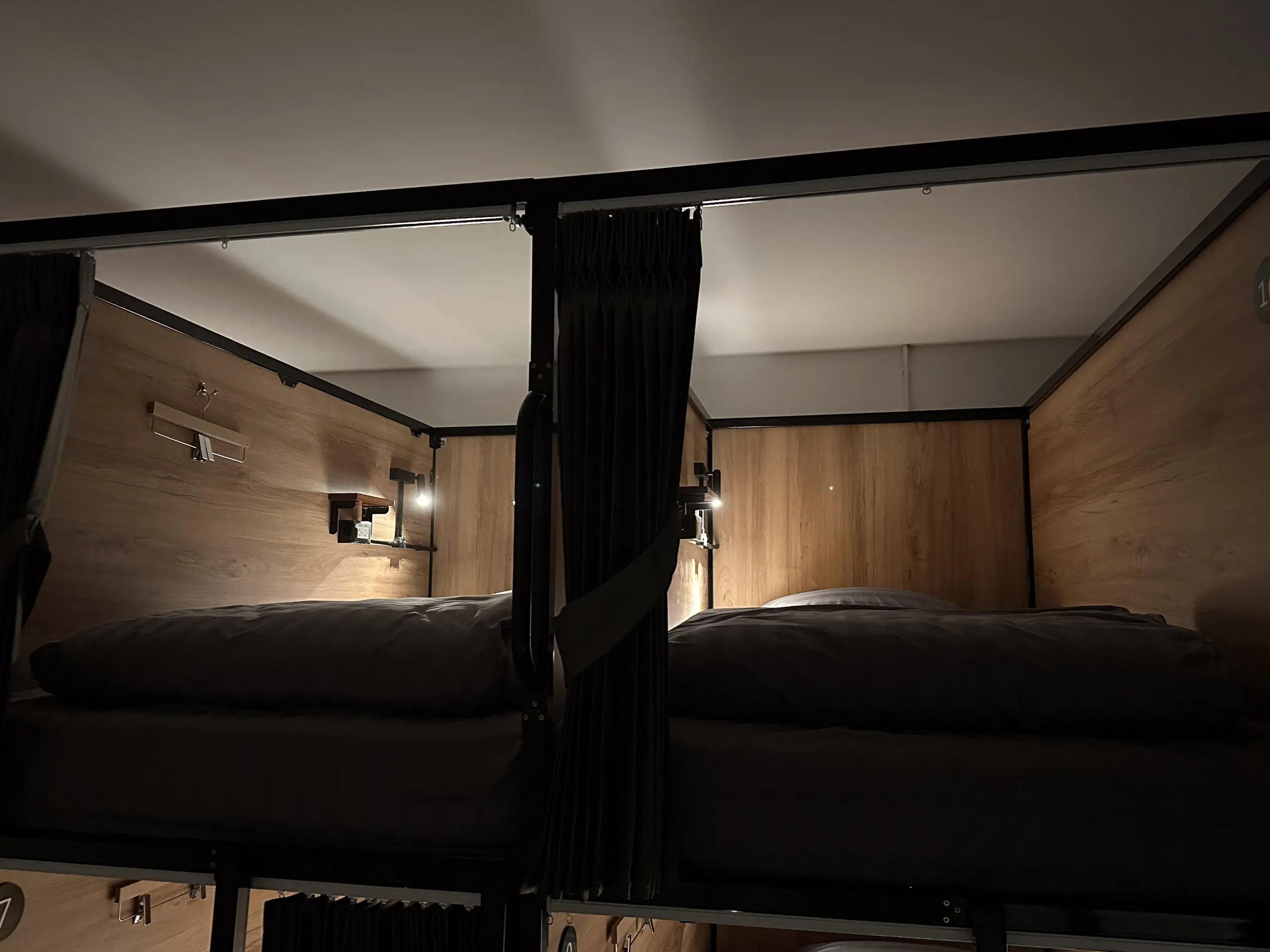Inside a capsule: mattress, wooden panelling, reading light and shelf