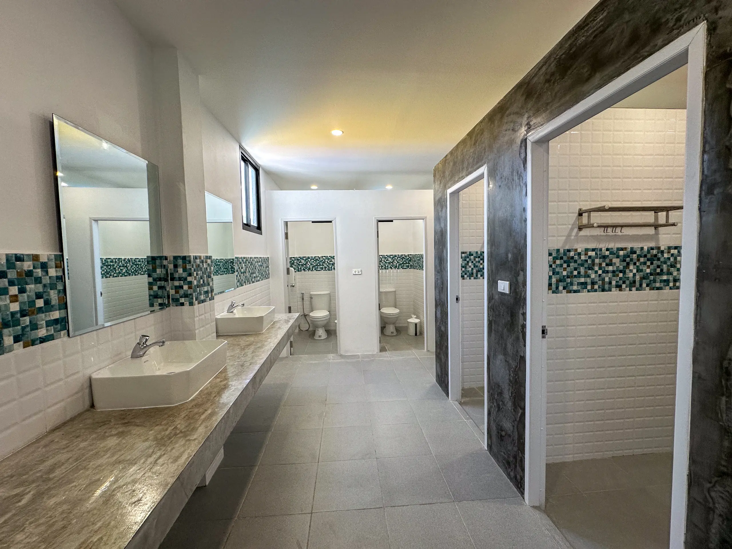 Shared bathroom with double vanity, mirrors and shower cubicles